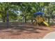 A neighborhood playground offers a swing set and colorful climbing structure with slides, set among mature trees and open space at 1233 Bramley Ln, Deland, FL 32720
