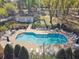The community pool is fenced and lined with tables, chairs, greenery, and a pool house at 1233 Bramley Ln, Deland, FL 32720