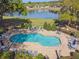 An inviting community pool is surrounded by lounge chairs and a serene lake view at 1233 Bramley Ln, Deland, FL 32720