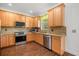Updated kitchen with stainless steel appliances, light wood cabinets, and granite countertops at 12720 Greco Dr, Orlando, FL 32824