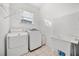 Bright laundry room features tile flooring, window, washer, dryer, and utility sink at 12720 Greco Dr, Orlando, FL 32824