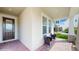 Cozy front porch with brick flooring, seating, and a decorative front door at 14345 Wabasso Loop, Winter Garden, FL 34787
