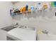 Functional laundry room with modern appliances, storage shelves, and a utility sink at 14345 Wabasso Loop, Winter Garden, FL 34787