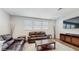 Comfortable living room featuring leather seating, stylish tables, and a modern entertainment center at 14345 Wabasso Loop, Winter Garden, FL 34787