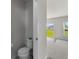 Compact bathroom with a toilet and a view of the backyard and living space at 1506 Finnigan Cir, Haines City, FL 33844