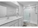 Bright bathroom featuring a double sink vanity with modern fixtures, a large mirror, and a glass-enclosed shower at 1506 Finnigan Cir, Haines City, FL 33844