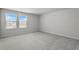 Vacant carpeted bedroom with two windows for natural light and white walls at 1506 Finnigan Cir, Haines City, FL 33844