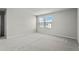 A vacant carpeted bedroom features two windows for natural light and access to another room at 1506 Finnigan Cir, Haines City, FL 33844