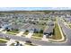 Aerial view of a residential street with identical homes, manicured lawns, and ample parking under a bright, sunny sky at 1506 Finnigan Cir, Haines City, FL 33844