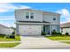 Charming two-story home features a two-car garage, manicured lawn, and a welcoming front entrance at 1506 Finnigan Cir, Haines City, FL 33844