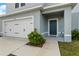 Inviting front entrance featuring a two-car garage, well-maintained landscaping, and a charming blue front door at 1506 Finnigan Cir, Haines City, FL 33844