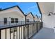 A modern balcony overlooks an identical row of homes with black railings against a blue sky backdrop at 1602 Park Lake St # 2, Orlando, FL 32803