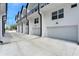 Row of modern townhomes, showcasing white exteriors with black accents and attached garages along a concrete driveway at 1602 Park Lake St # 2, Orlando, FL 32803