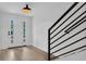 Bright foyer features a modern front door, light wood flooring, and black metal staircase railing at 1602 Park Lake St # 2, Orlando, FL 32803