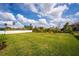 Spacious backyard featuring a well-maintained lawn, white fencing, and beautiful landscaping at 1639 Meadowlark Dr, Deltona, FL 32725