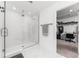 Bright bathroom with a glass enclosed shower and walk in closet with built-in shelving at 1639 Meadowlark Dr, Deltona, FL 32725