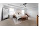Bright bedroom with a ceiling fan, neutral walls, carpet flooring, and a decorative rug under the bed at 1639 Meadowlark Dr, Deltona, FL 32725