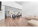 Open-concept living room featuring wood floors, modern furniture, and a seamless flow to the kitchen and dining area at 1639 Meadowlark Dr, Deltona, FL 32725