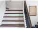 Elegant staircase with dark wood steps, white risers, and a black iron railing, adding a touch of sophistication at 1639 Meadowlark Dr, Deltona, FL 32725