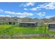 Well-maintained backyard featuring a screened-in patio and lush green grass, enclosed by a black metal fence at 16781 Wingspread Loop, Winter Garden, FL 34787