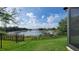 Lush backyard with a scenic lake view, enhanced by a sturdy black metal fence at 16781 Wingspread Loop, Winter Garden, FL 34787