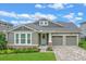 Charming home featuring a two-car garage, well-manicured lawn, and a welcoming front porch at 16781 Wingspread Loop, Winter Garden, FL 34787