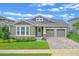 Charming single-story home with a manicured lawn, brick accents, a two-car garage, and beautiful landscaping at 16781 Wingspread Loop, Winter Garden, FL 34787