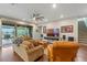 Open-concept living room with patio access, hardwood flooring, ceiling fan, and cozy seating at 16781 Wingspread Loop, Winter Garden, FL 34787