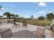 Community patio area with lounge chairs and tables, overlooking a serene lake view and lush greenery at 16781 Wingspread Loop, Winter Garden, FL 34787