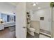 Modern bathroom featuring tiled walk-in shower, floating shelves, and views of bedroom at 2136 Topping Pl, Eustis, FL 32726