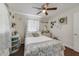 Charming bedroom features a ceiling fan, wood floors, decorative accents, and a cozy bed with floral accents at 2136 Topping Pl, Eustis, FL 32726