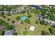 Aerial shot featuring tennis courts, basketball court, playground, and green spaces interspersed with homes and a pond at 2140 Lilypad Ln, Windermere, FL 34786