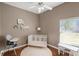 Neutral Bedroom with hardwood floors features a white crib, high chair, shelves, and plenty of natural light at 2140 Lilypad Ln, Windermere, FL 34786