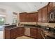 Well-equipped kitchen with dark cabinetry, granite countertops, and stainless steel appliances at 2140 Lilypad Ln, Windermere, FL 34786
