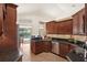 Open concept kitchen featuring dark cabinets, granite counters, and a view of the pool at 2140 Lilypad Ln, Windermere, FL 34786