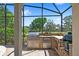 A beautiful outdoor kitchen featuring a grill and mini-fridge, offering a perfect setting for outdoor cooking and dining at 2140 Lilypad Ln, Windermere, FL 34786