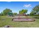 Community playground with swings, slide, and climbing structure surrounded by green space and mature trees on a sunny day at 2140 Lilypad Ln, Windermere, FL 34786
