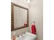 Powder room featuring a decorative mirror, a red towel, a pedestal sink and modern plumbing at 2140 Lilypad Ln, Windermere, FL 34786