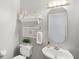 Powder room featuring a decorative mirror, coastal decor, a pedestal sink and a commode at 2140 Lilypad Ln, Windermere, FL 34786