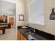 A convenient wet bar near the game room with a granite countertop and stainless steel sink at 2140 Lilypad Ln, Windermere, FL 34786