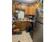 Compact kitchen featuring wood cabinets and essential appliances, with a tiled backsplash at 227 Strawberry Ln, Daytona Beach, FL 32117