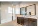 Modern bathroom featuring a double sink vanity with granite countertops and a glass-enclosed shower and soaking tub at 2653 Roadster Ln, Kissimmee, FL 34746