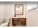 Clean and simple powder room features a modern vanity with white countertop, dark cabinets and a framed mirror at 2653 Roadster Ln, Kissimmee, FL 34746