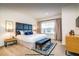 Well-lit bedroom featuring a padded headboard, a bench, and contemporary bedside tables at 2653 Roadster Ln, Kissimmee, FL 34746