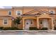 Inviting exterior of a two-story townhome with a red tile roof and a well-manicured front yard at 2653 Roadster Ln, Kissimmee, FL 34746