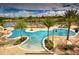 Large freeform community pool with palm trees, surrounded by lounge chairs, and beautiful residential buildings in the background at 2653 Roadster Ln, Kissimmee, FL 34746