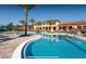 Large resort style swimming pool surrounded by palm trees, lounge chairs and a sunny deck area with a partial waterslide at 2653 Roadster Ln, Kissimmee, FL 34746