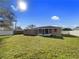 Exterior view of the house showcasing a well-maintained backyard, privacy fence, and screened patio at 2936 Woodcrest Ln, Lakeland, FL 33805