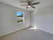 Bedroom with neutral carpeting, a ceiling fan, and a large window offering a view of the outdoors at 2936 Woodcrest Ln, Lakeland, FL 33805