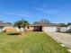 Charming single-story home with a well-manicured lawn, driveway, and a white garage door under a sunny sky at 2936 Woodcrest Ln, Lakeland, FL 33805